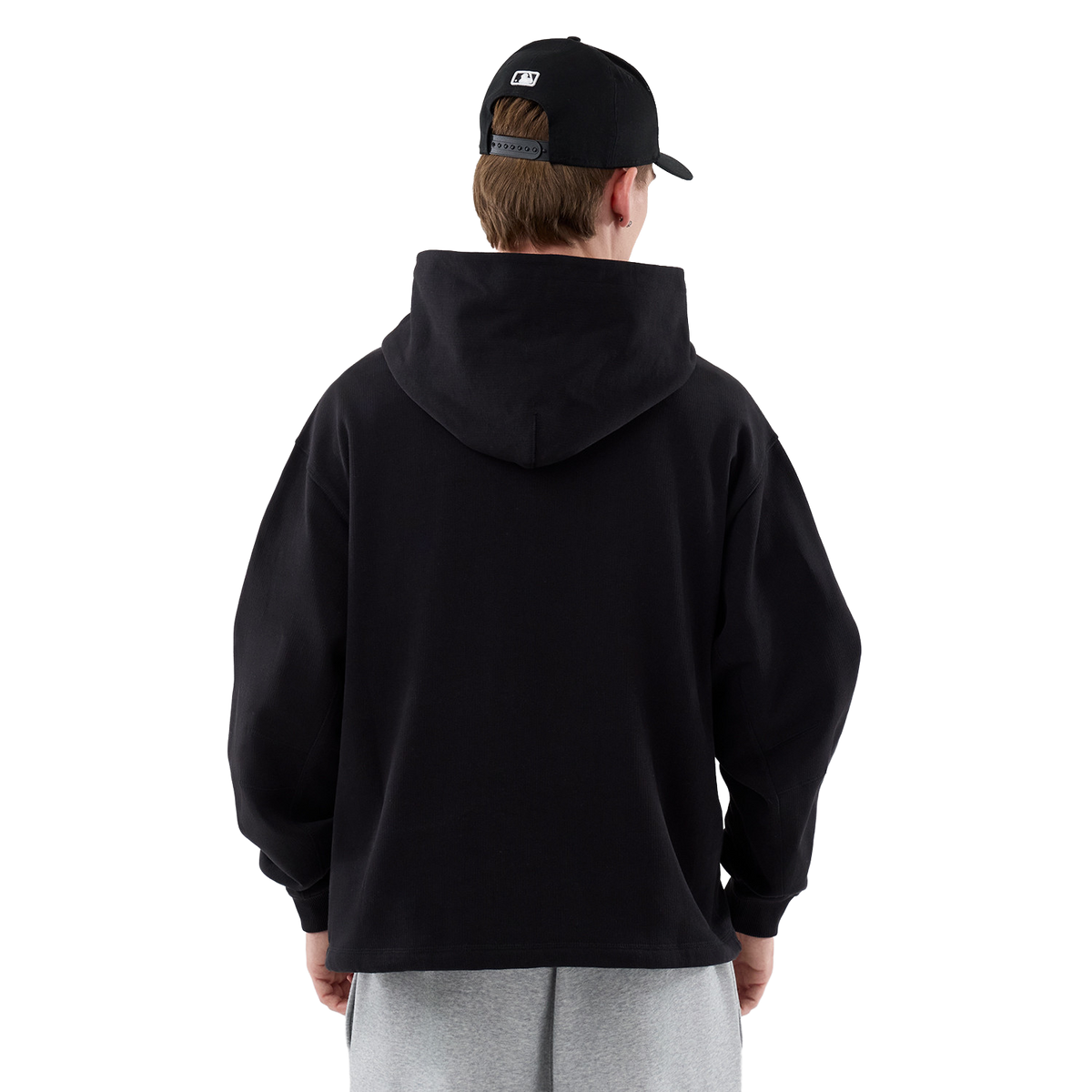 New Era Hoodie in Schwarz, Model von hinten in voller Figur