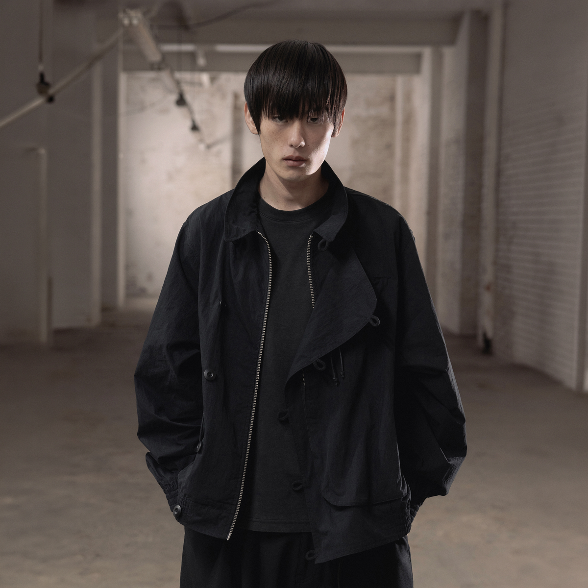 SCRT Distorted Blouson Jacke in Schwarz, Model von vorne in Lagerhalle